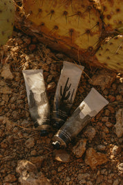 Three tubes of cream or lotion on a textured, natural surface.