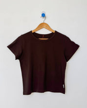 Brown t-shirt on a wooden hanger against a white background